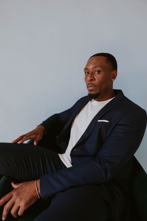 A person in a suit sitting
Description automatically generated with low confidence